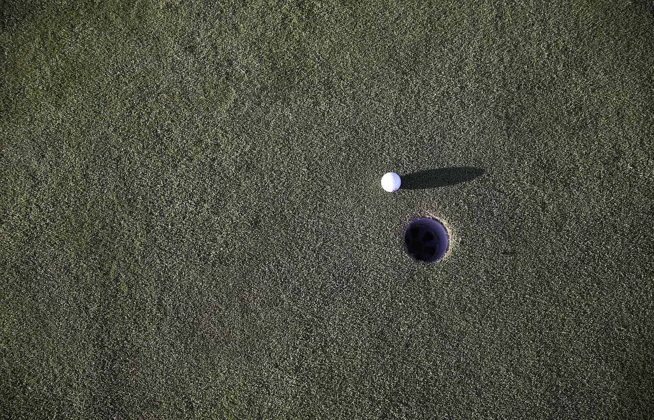 Golfbold ved et hul på en puttinggreen